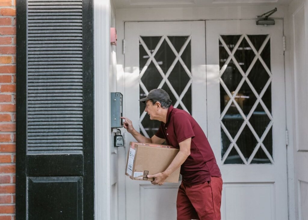 Courier in uniform delivering an online order at a residential front door
