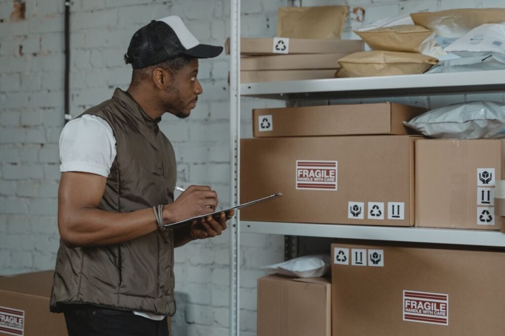 Courier checking packages ready for nationwide shipping in a warehouse